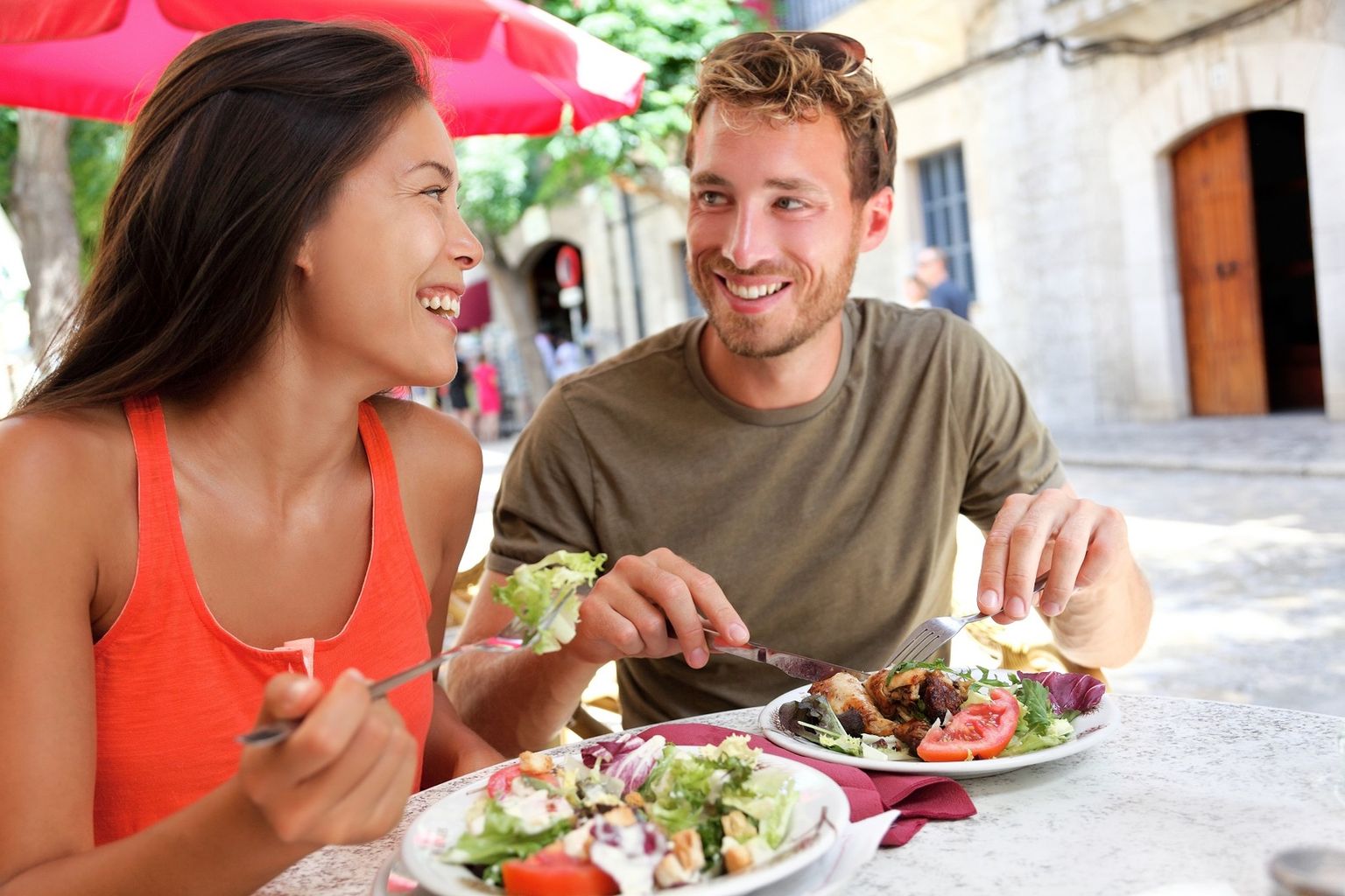 Zwei Menschen Essen in einem Restaurant und lächeln sich dabei an.
